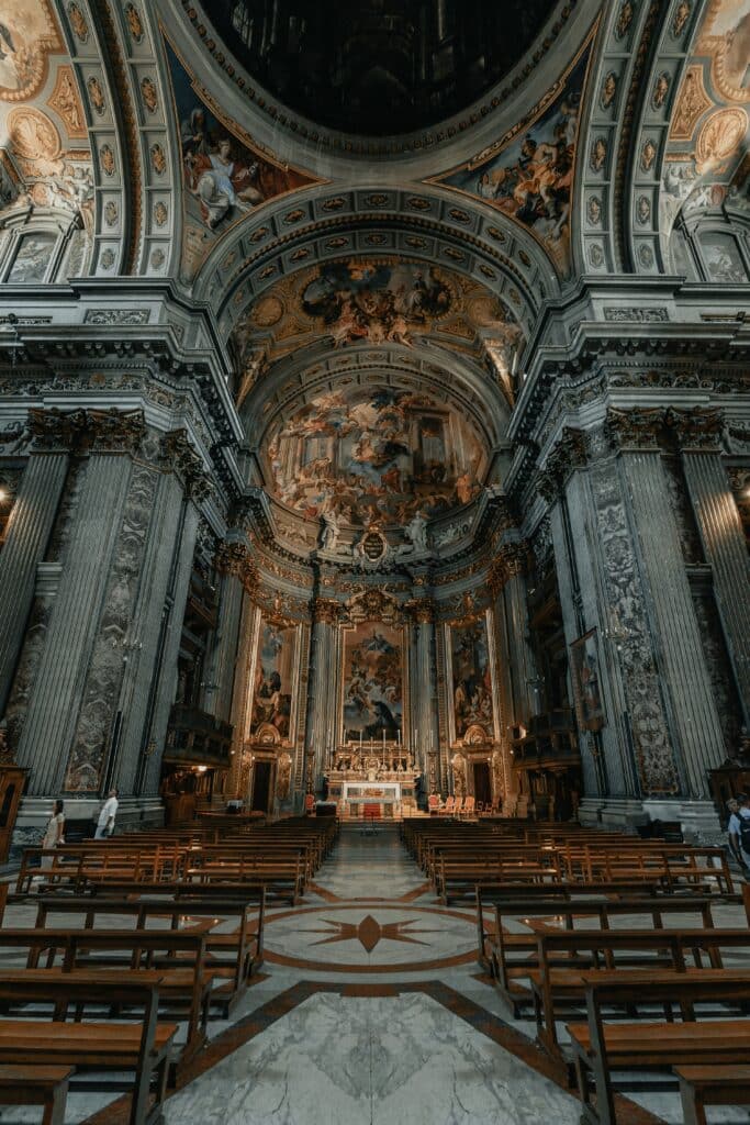 Baroque nave lined with pews, under a painted dome